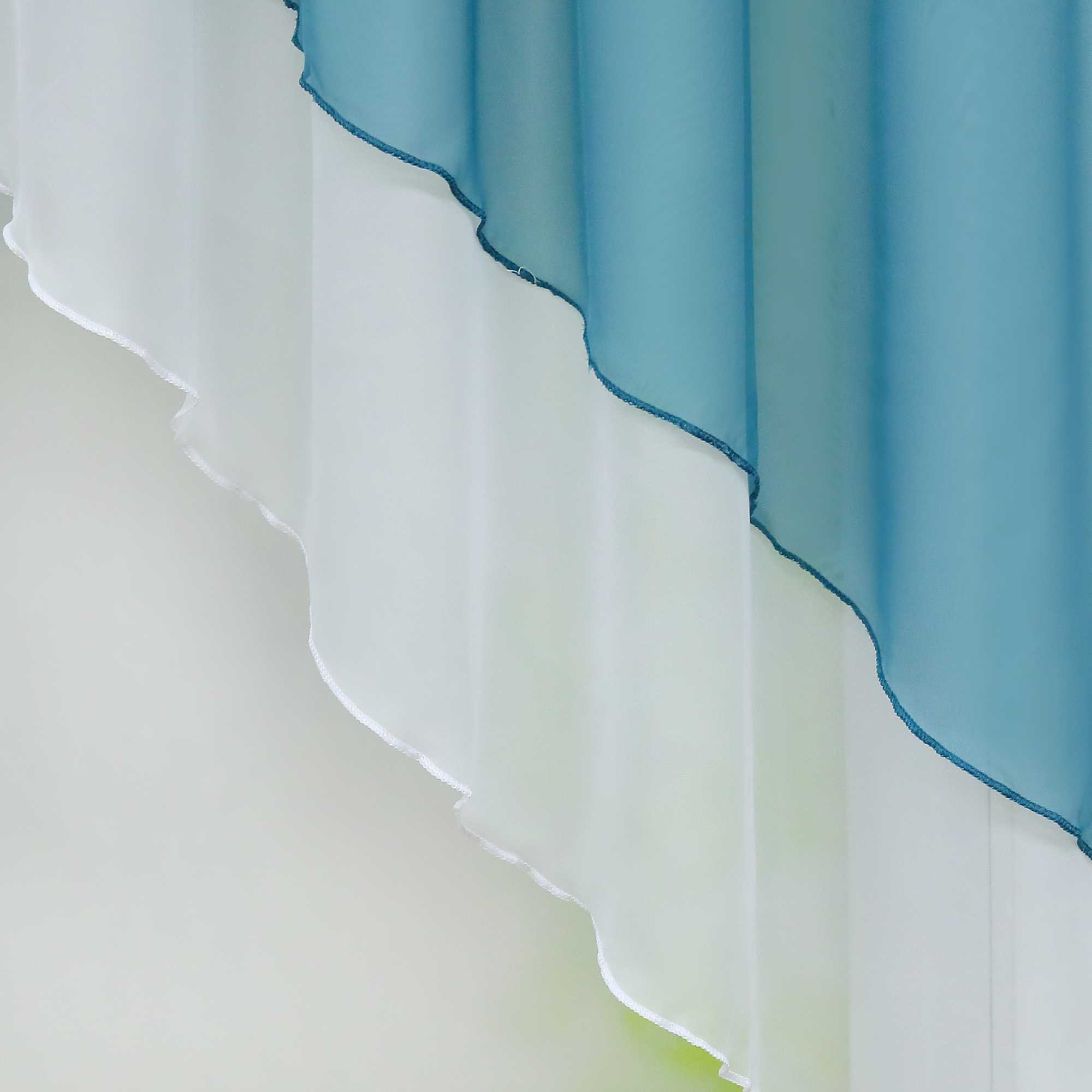 Nahaufnahme eines blauen halbtransparenten Gardinenstoffs mit gewellten, sanft fallenden Kanten. Das Licht hebt die feine Struktur des Stoffes hervor, während der Hintergrund in einem sanften Grünton verschwimmt.