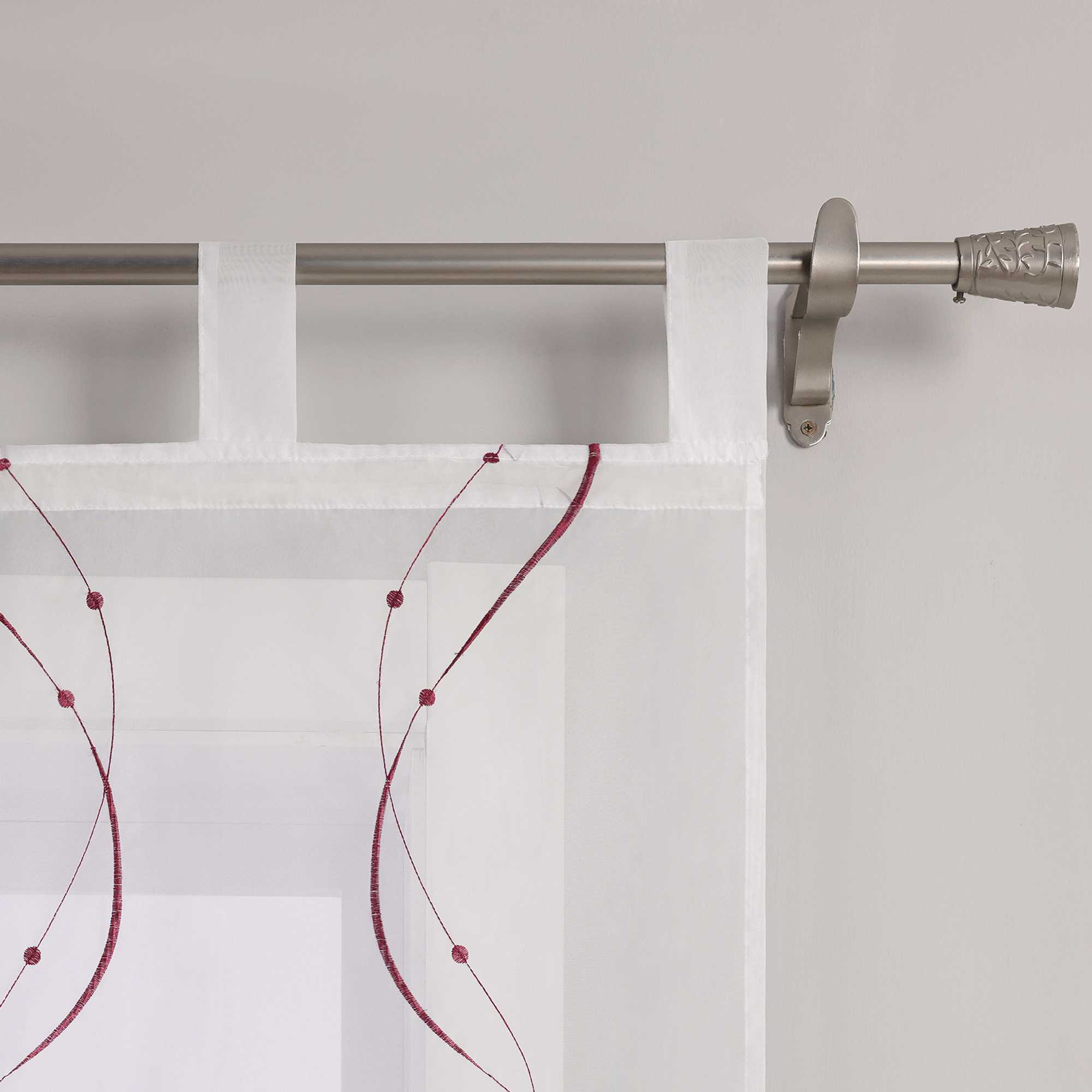 Auf dem Bild ist ein Detail der Schlaufen einer weissen Gardine zu sehen. Die Gardine ist mit feinen, lila wellenfoermigen Naehten versehen, deren Enden kleine Punkte bilden. Die Gardine ist mithilfe gleichmaessiger weisser Schlaufen an einer Metallstange aufgehaengt. Die Naehte sind sauber verarbeitet, das Material wirkt hochwertig.