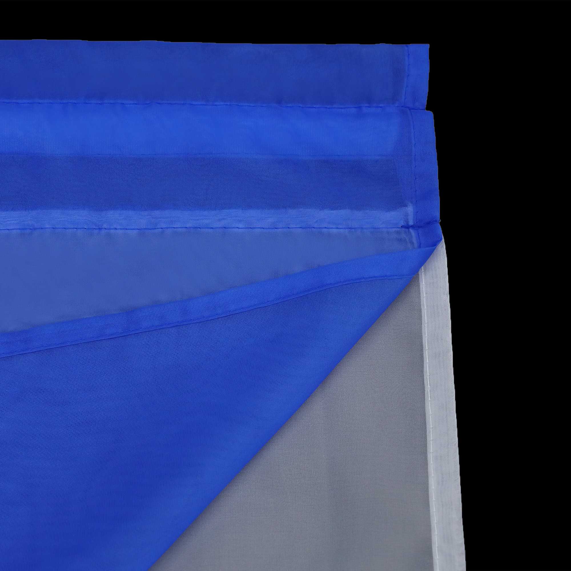 Detail eines marineblauen, halbtransparenten Gardinenstoffs mit sauber gefalteten Kanten. Die umgeschlagenen Kanten sind sauber und fein gepresst, und die oberste Lage des marineblauen Gardinenstoffs ist gegenüber dem darunter liegenden weißen Stoff halbdurchlässig.