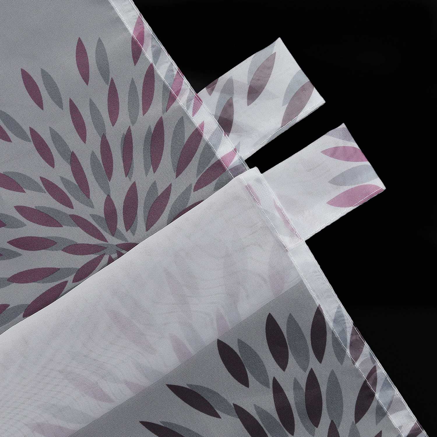Die aufhängung der violetten Feuerwerks-Scheibengardine zeigt die präzise und sauber genähte Schlaufe, die stabil und dekorativ ist. Die violette Feuerwerksgrafik auf der Schlaufe ergänzt die Designästhetik der Gardine, was das Gesamtbild der Fensterdekoration weiter verfeinert. Die hochwertige Verarbeitung und das feine Nahtbild machen diese Gardine sowohl funktional als auch optisch ansprechend. Ideal für eine festliche Fensterdekoration mit einem Hauch von Eleganz.