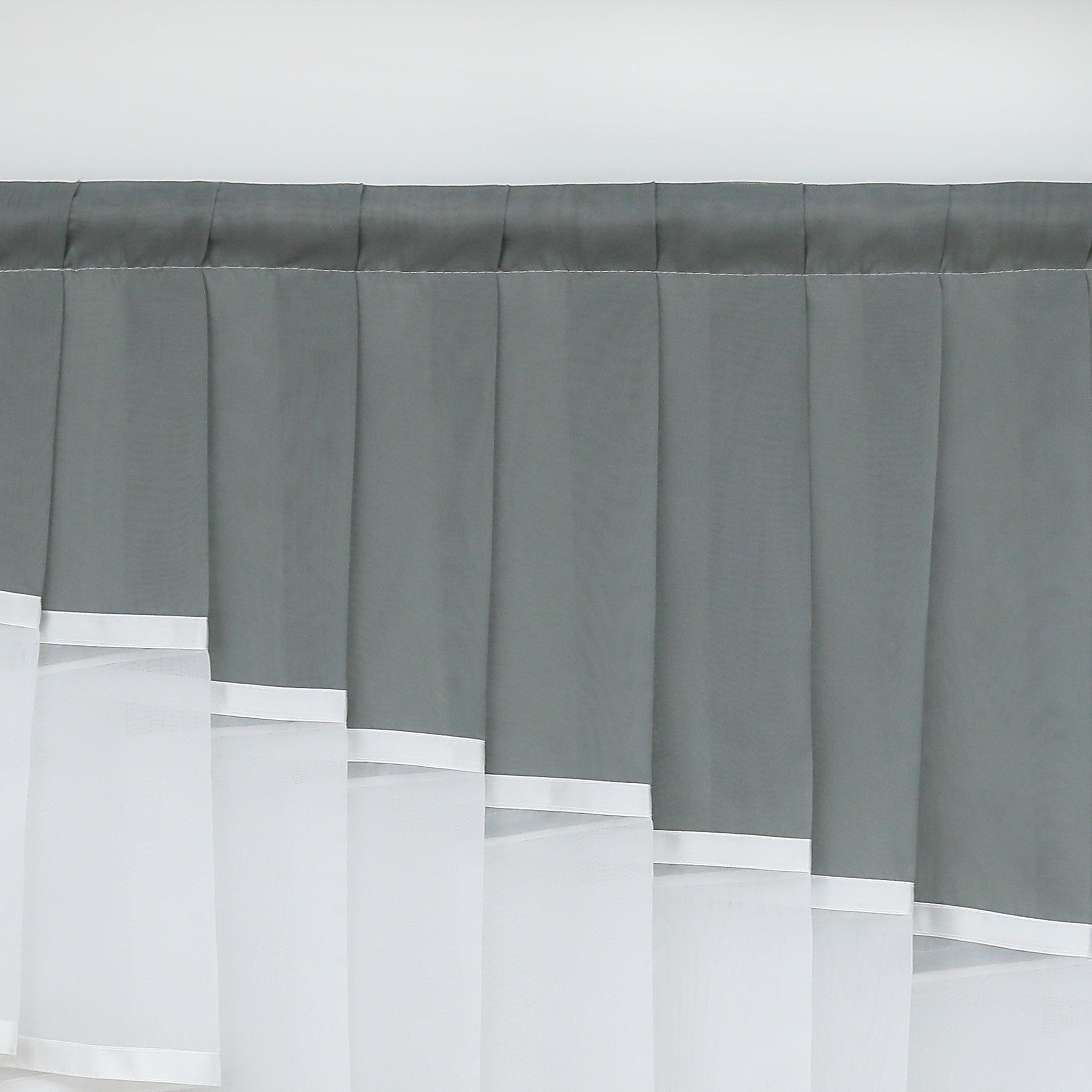 Dies ist ein Ausschnitt eines Fensters mit einem eleganten Vorhang. Der obere Teil besteht aus dunkelgrauem Stoff mit gleichmäßigen Falten, während der untere Teil nahtlos mit weißem, transparentem Stoff verbunden ist. Der weiße Stoff hat dekorative Kanten und verleiht dem Vorhang ein ansprechendes, dekoratives Aussehen. Perfekt für die Fensterdekoration im Wohnbereich.