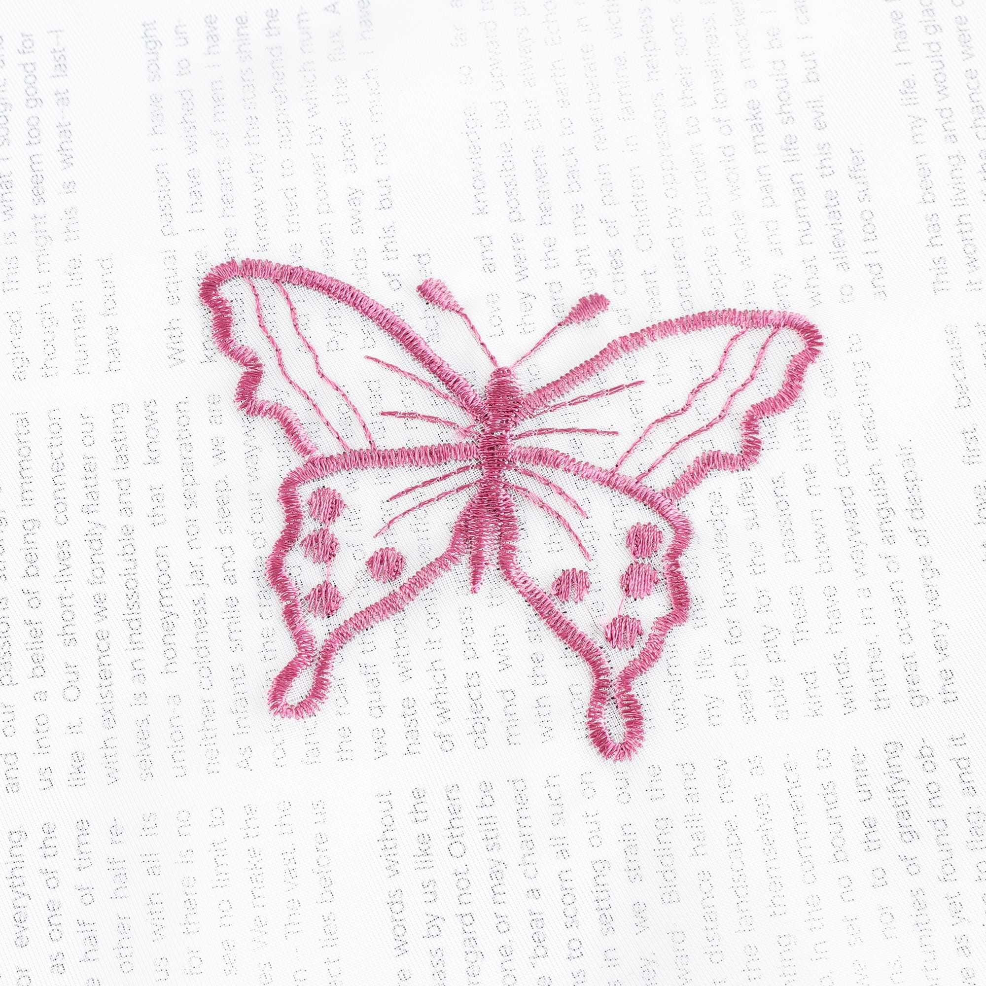 Nahaufnahme einer lila Schmetterlingsstickerei, die auf einem transparenten weißen Stoff flach ausgebreitet liegt. Die lila Schmetterlinge sind sorgfältig in das Gewebe eingearbeitet.
