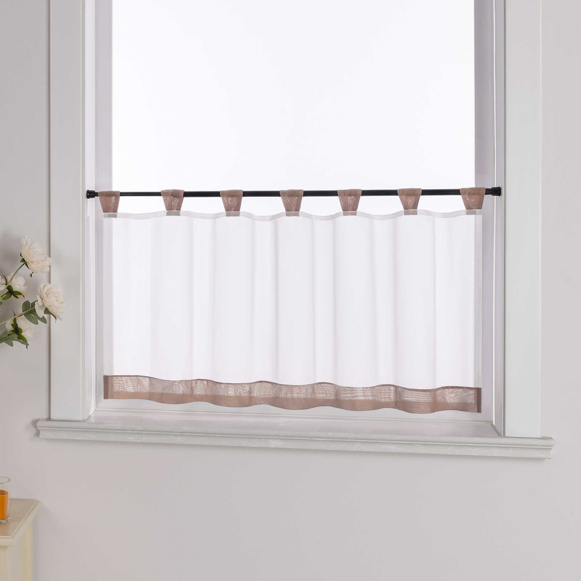 Die braune Scheibengardine hängt vor einem Fenster, während die weiße Hintergrundwand im Hintergrund sichtbar bleibt. Der transparente Vorhang lässt das Licht durch, während er von blumigen Dekorationen an der Seite sanft ergänzt wird, was dem Raum eine leichte und frische Atmosphäre verleiht.
