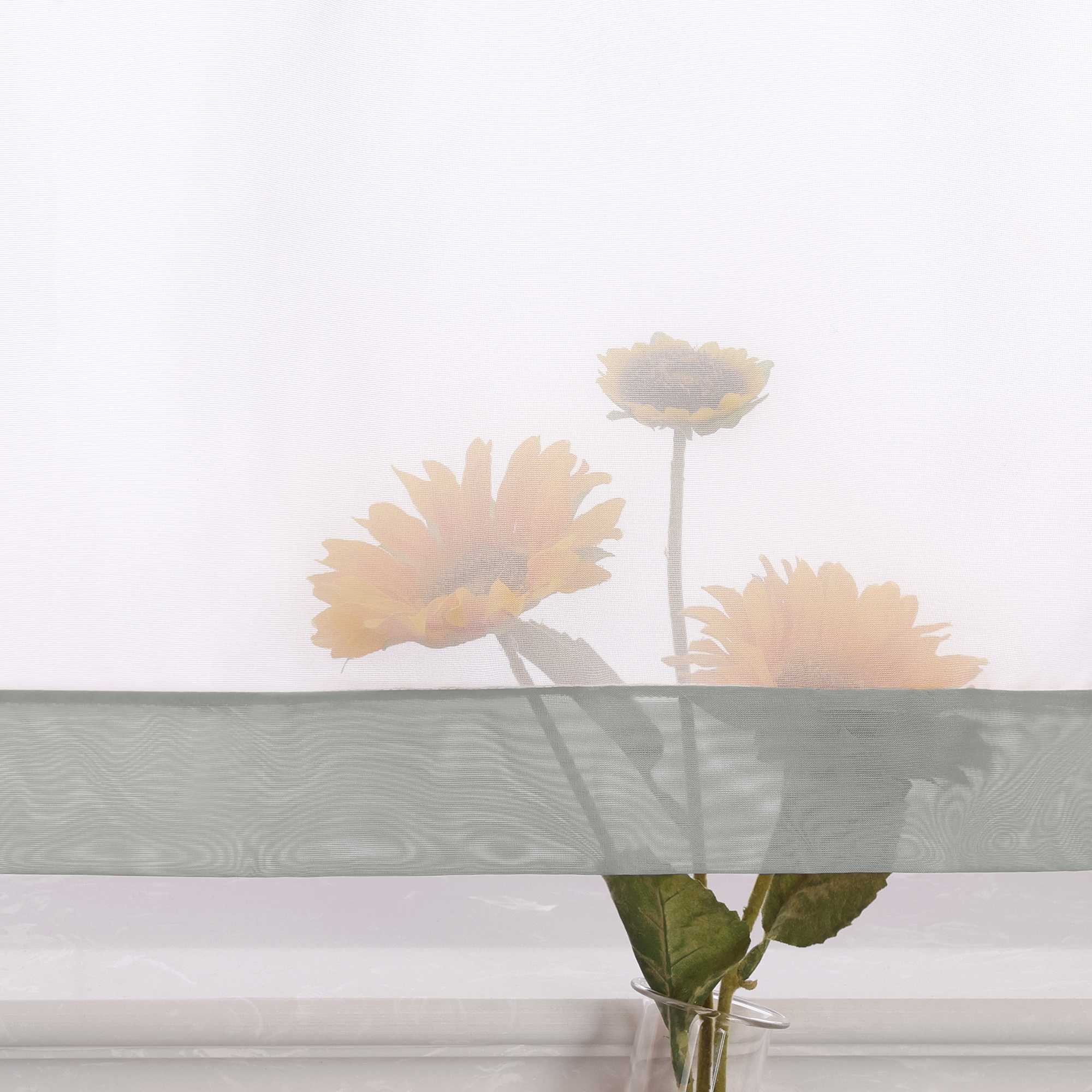 Die Unterkante des Vorhangs wird im Detail gezeigt, mit einer leichten Transparenz, die den Blick auf eine Büschel von Sonnenblumen im Hintergrund freigibt. Die sanfte Durchsicht des Vorhangs lässt das natürliche Licht durch und schafft eine harmonische Atmosphäre, während die Blumen dezent hervorblitzen.