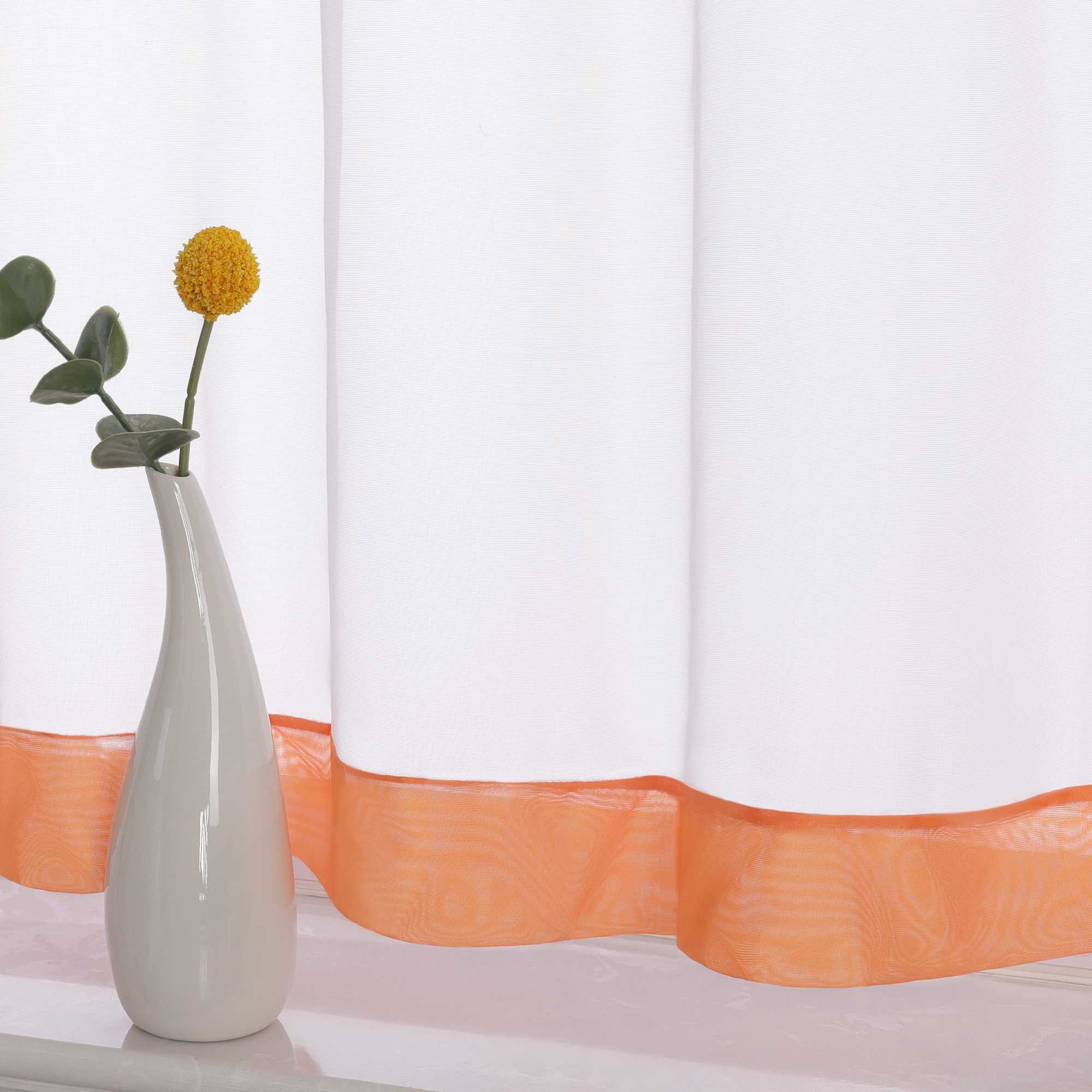 Die Unterkante des Vorhangs wird im Detail gezeigt, mit einem orange Dekorband als stilvollem Akzent. Ein Vase im Vordergrund ergänzt die Szene und fügt dem Raum eine harmonische, dekorative Note hinzu, die den eleganten Look des Vorhangs unterstreicht.